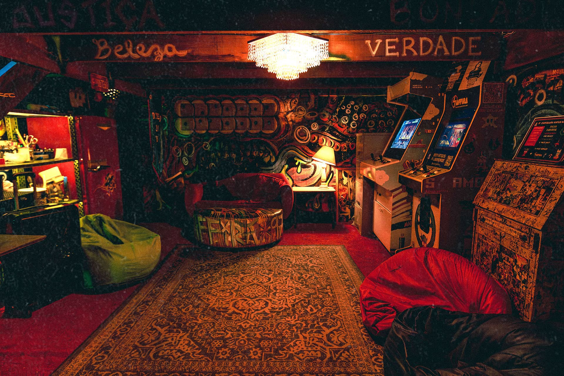 Área de lazer com iluminação vermelha e máquinas de arcade