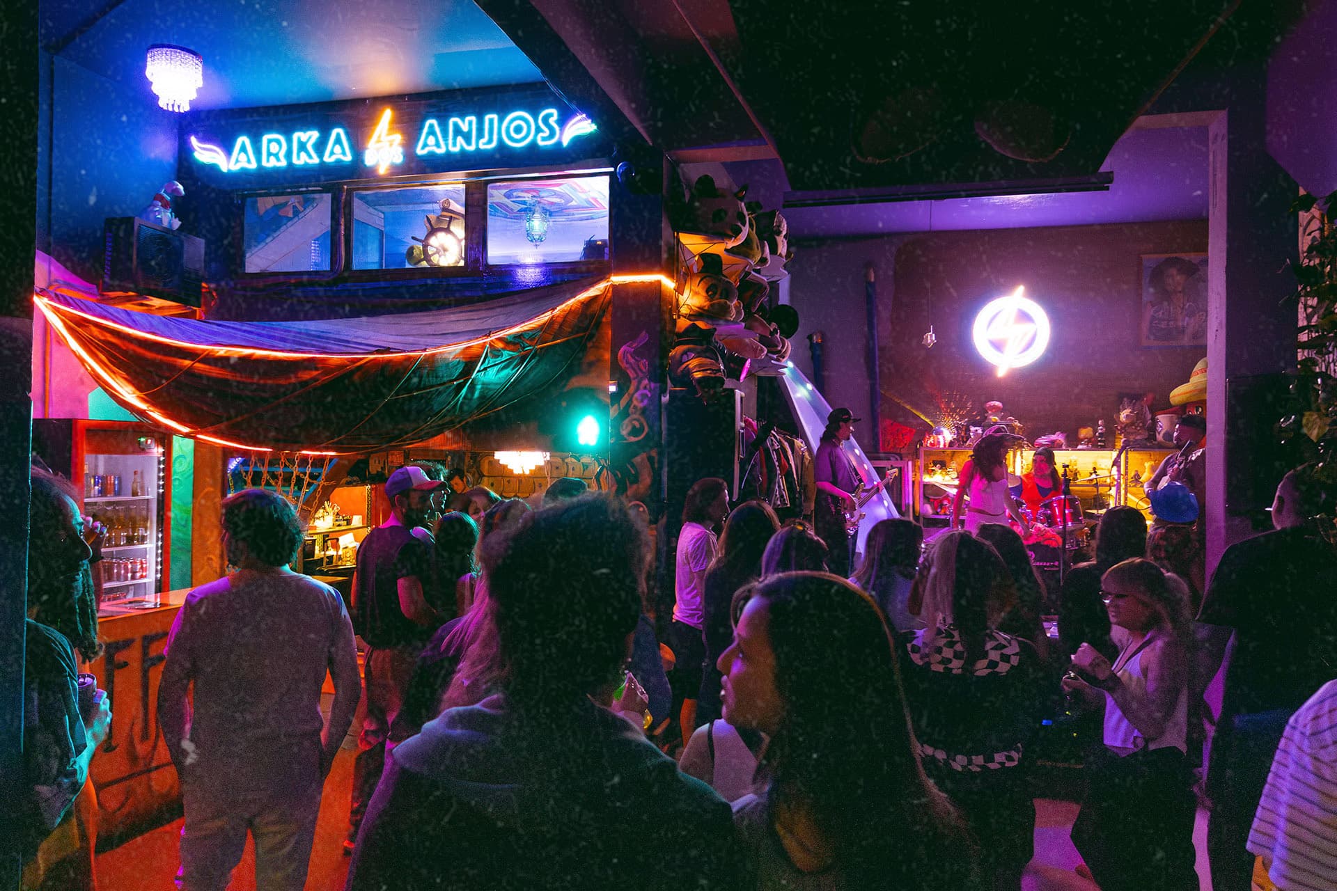 Espaço de eventos com público e letreiro neon